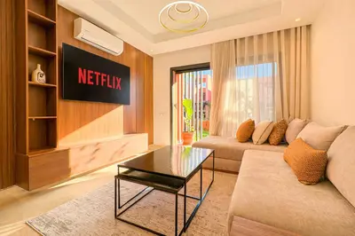 a living room with a couch and a table at Appartement KENZ Nouria avec piscine in Marrakech