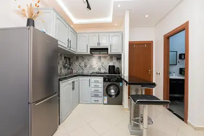 a kitchen with white cabinets and a stainless steel refrigerator at Red City Elegant Stay in Marrakech