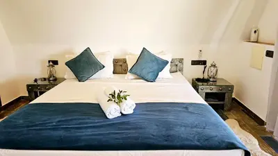 a bedroom with a large bed with blue pillows at Oasis Of peace Chalet A-frame Atlas view in Aït Amara