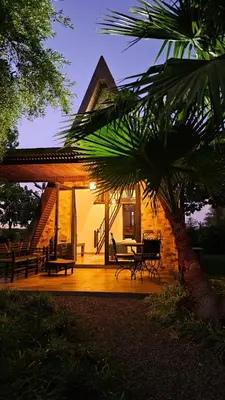 a house with a patio with a table and chairs at Oasis Of peace Chalet A-frame Atlas view in Aït Amara