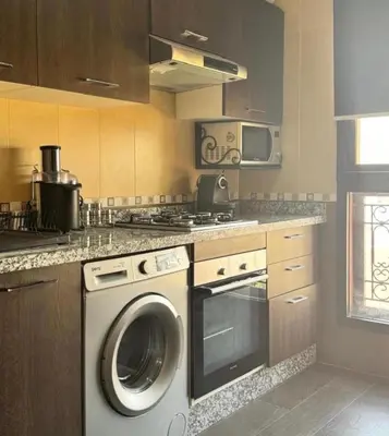 a kitchen with a washing machine and a stove at Résidence Caricia - WiFi, Piscine, Parking, Gardien h24 in Marrakech