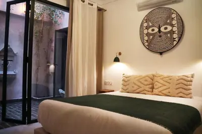 a bedroom with a bed and a clock on the wall at Dar Helen in Marrakech