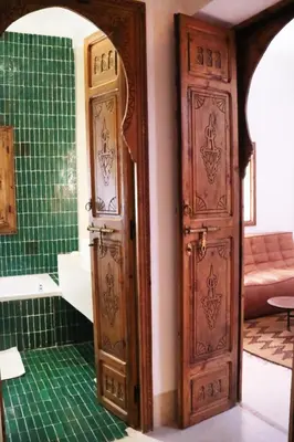 a bathroom with two wooden doors in a room at Dar Helen in Marrakech