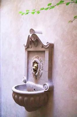 a stone fountain on the side of a building at Dar Helen in Marrakech
