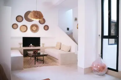 a living room with a white couch and a fireplace at Dar Helen in Marrakech