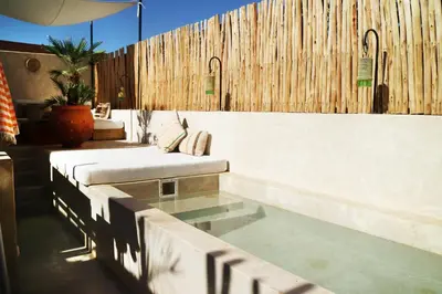 a swimming pool with a couch and a table at Dar Helen in Marrakech
