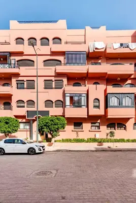 a pink building with a car parked in front of it at Premium Holliday Marrakesh in Marrakech