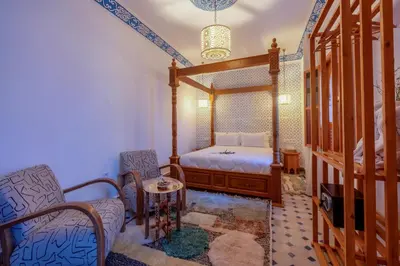 a bedroom with a bed and a table and chairs at Riad Secret De Medina in Marrakech