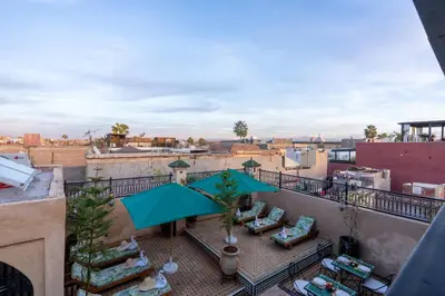 a view of a balcony with chairs and an umbrella at Riad Secret De Medina in Marrakech