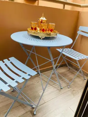 a blue table with two cups and two chairs at Apparemment cosy pour famille in Marrakech