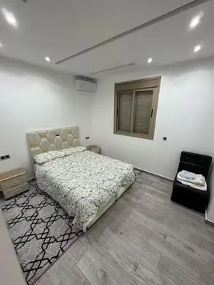 a white bedroom with a bed and a window at Apparemment cosy pour famille in Marrakech