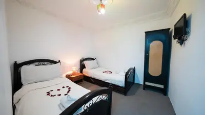 a room with two beds and a tv in it at Mizo House in Marrakech