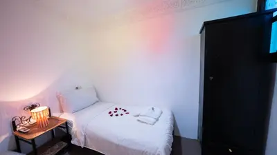 a small bedroom with a white bed and a table at Mizo House in Marrakech
