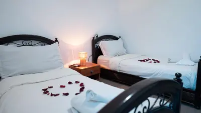 a bedroom with two beds with roses on the sheets at Mizo House in Marrakech