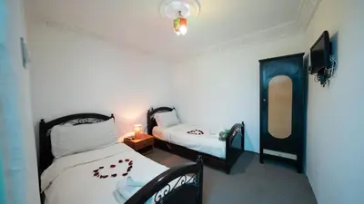 a bedroom with two beds and a lamp and a mirror at Mizo House in Marrakech