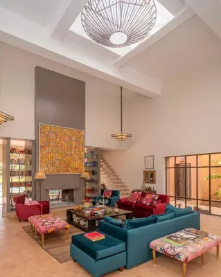a living room with blue couches and red chairs at Villa DarJ in Marrakech