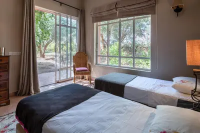 a bedroom with two beds and a window at Villa DarJ in Marrakech