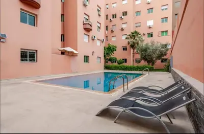 a swimming pool with a bench next to a building at Prestige Gueliz city centre appartement in Marrakech
