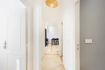 a hallway with white walls and a chandelier at Luxe et calme en plein centre de Marrakech in Marrakech