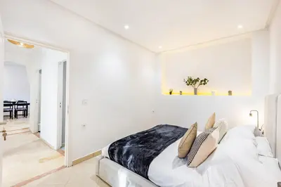 a bedroom with white walls and a bed with pillows at Luxe et calme en plein centre de Marrakech in Marrakech