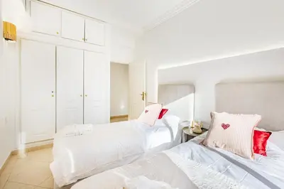 two beds in a bedroom with white walls and red pillows at Luxe et calme en plein centre de Marrakech in Marrakech