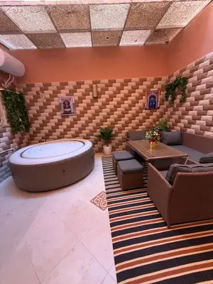 a room with a hot tub and a table and chairs at Dar des étoiles in Marrakech