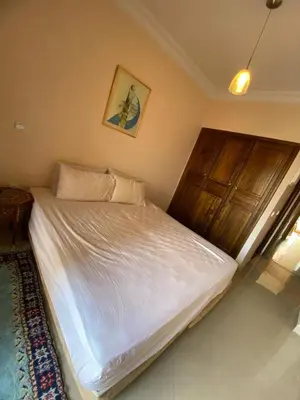 a bed in a bedroom with a picture on the wall at اقامة كنزي مراكش كليز in Marrakech