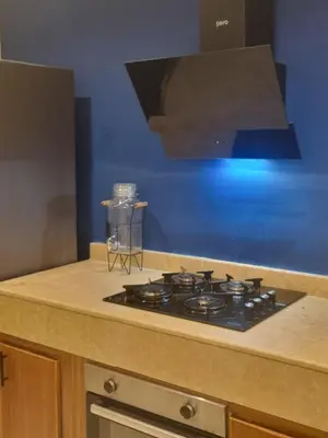 a stove top in a kitchen with a blue wall at La Boheme City Center Entire Unique Appart 3Bdr 3Bthr in Marrakech