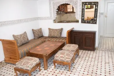 a living room with a couch and a table at Riad authentique dans une résidence sécurisée in Marrakech