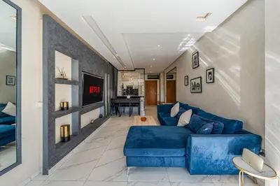 a living room with a blue couch and a table at Sunny Getaway with Pool Access & Private Yard in Marrakech