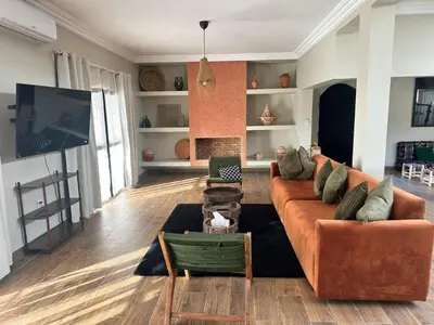 a living room with a couch and a tv at Villa Léa 2 Marrakech in Marrakech