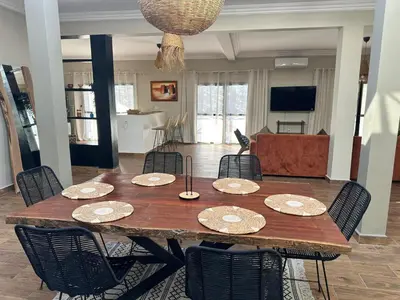 a wooden table with chairs and a dining room at Villa Léa 2 Marrakech in Marrakech