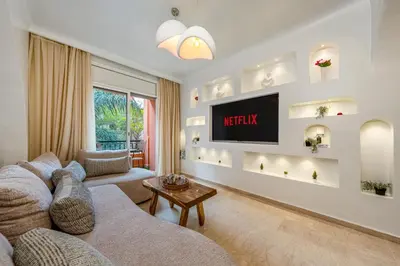 a living room with a couch and a tv on a wall at White Oasis Swimming pool and Design in Marrakech