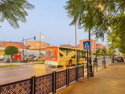 a yellow bus driving down a city street at White Oasis Swimming pool and Design in Marrakech