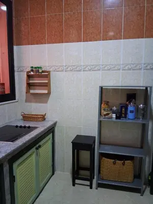 a kitchen with a sink and a counter with a stool at Casa Rosa in Marrakech
