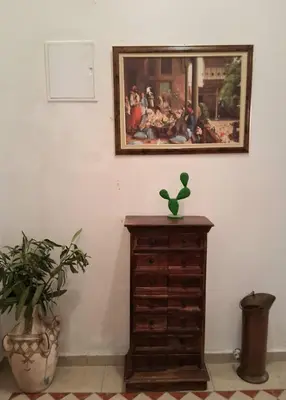 a painting on the wall above a dresser with a plant at Casa Rosa in Marrakech