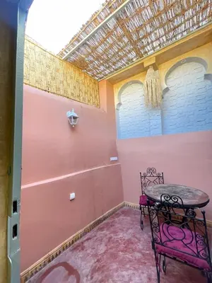 a pink room with a table and a chair at Riad Elegant suite in the heart of the Medina in Marrakech
