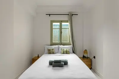 a bedroom with a large white bed with a window at Modern studio with terrace in Marrakech