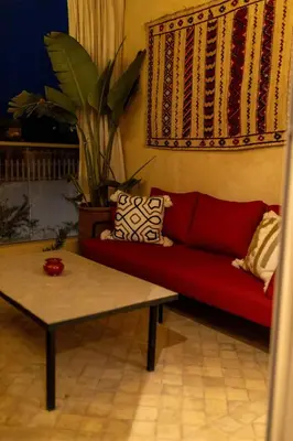 a living room with a red couch and a table at Casaterra Luxury apartment with pool & home-cinema in Marrakech