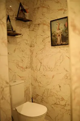 a bathroom with a toilet and a picture on the wall at Casaterra Luxury apartment with pool & home-cinema in Marrakech