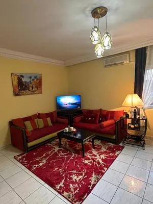 a living room with a red couch and a red rug at Appartement, centre-ville, Marrakech, Gueliz in Marrakech