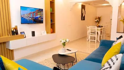 a living room with a blue couch and a tv at the sweet night of Marrakech in Marrakech