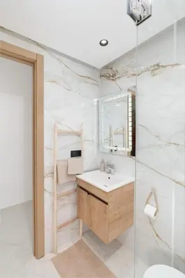 a bathroom with a sink and a glass shower at Dar élégant au centre de Marrakech piscine in Marrakech