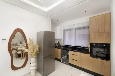 a kitchen with a stainless steel refrigerator and a mirror at Dar élégant au centre de Marrakech piscine in Marrakech