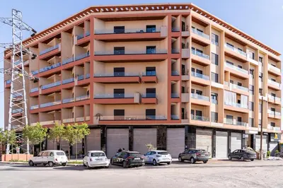 a large apartment building with cars parked in front of it at Dar élégant au centre de Marrakech piscine in Marrakech
