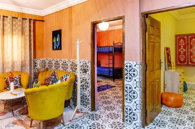 a living room with yellow chairs and a table at Appartement traditionnel au médina in Marrakech