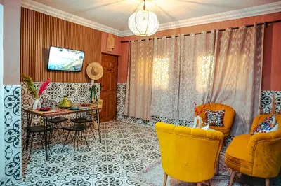 a living room with yellow chairs and a table at Appartement traditionnel au médina in Marrakech