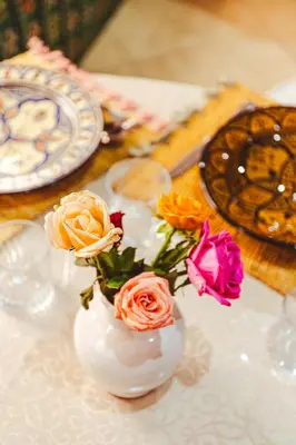a white vase filled with flowers on a table at Appartement traditionnel au médina in Marrakech