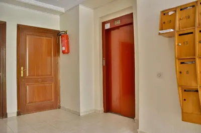 a hallway with a red door and a red fire extinguisher at Dar Kech Luxury et comfort in Marrakech