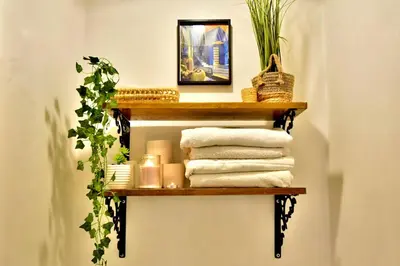 a shelf in a bathroom with towels and a plant at Dar Kech Luxury et comfort in Marrakech
